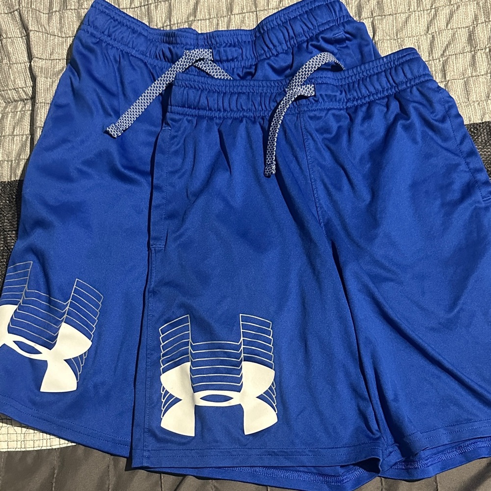 TWO PAIRS of under armour boys blue shorts. 1 size small, 1 size medium.